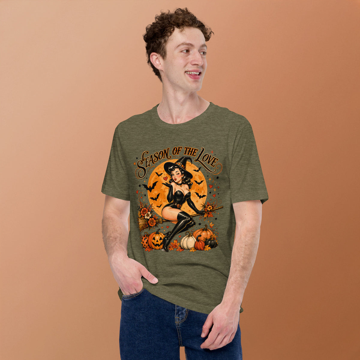 Young man smiling and modeling the Season of the Witch retro graphic t-shirt in heather olive