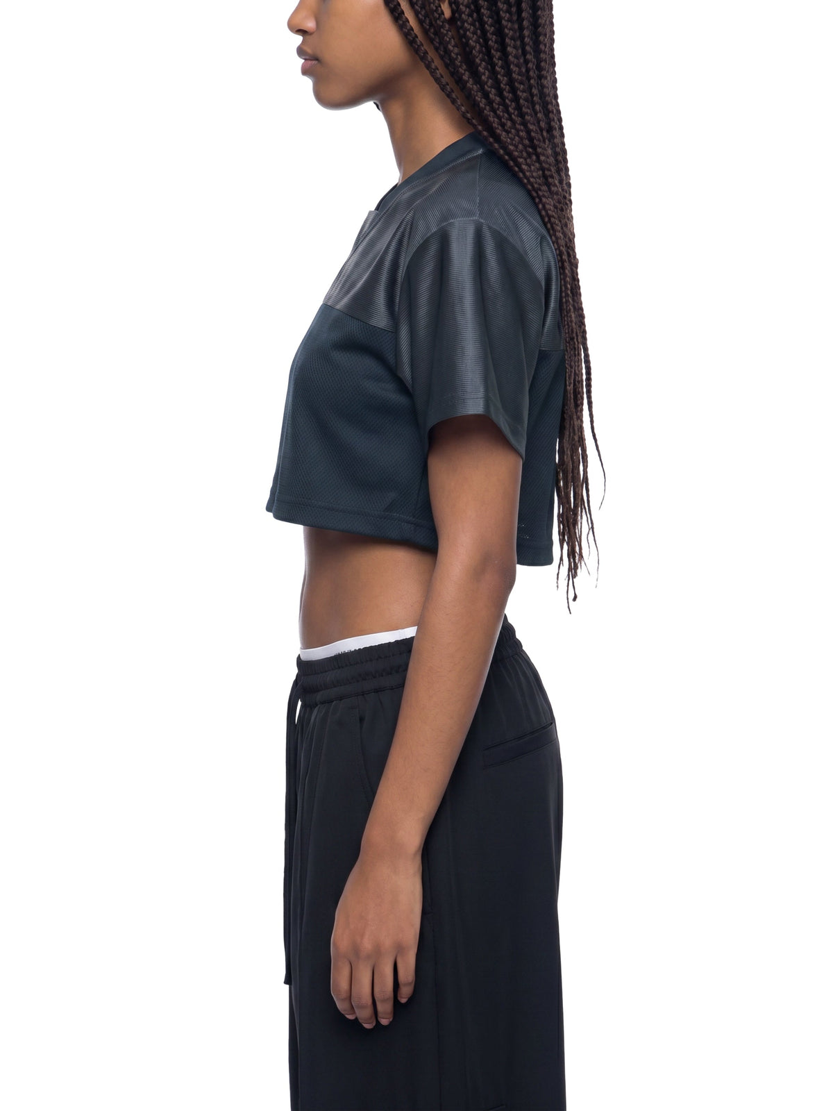 Clothing By Hot Takes Designs black cropped paneled jersey with a V-neck, worn by a model in a side profile view.
