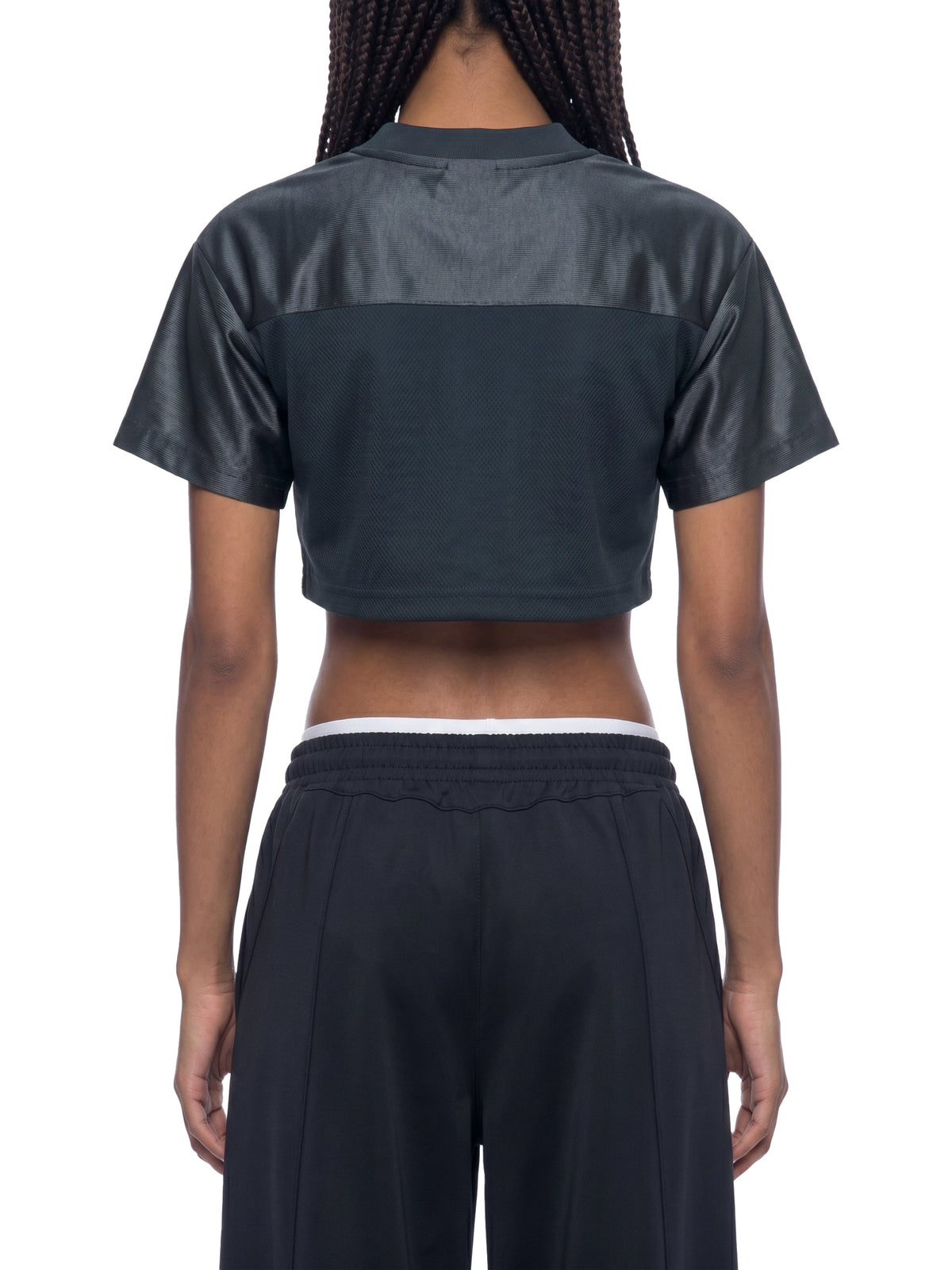 Clothing By Hot Takes Designs black cropped jersey with paneled detailing, back view on a model.