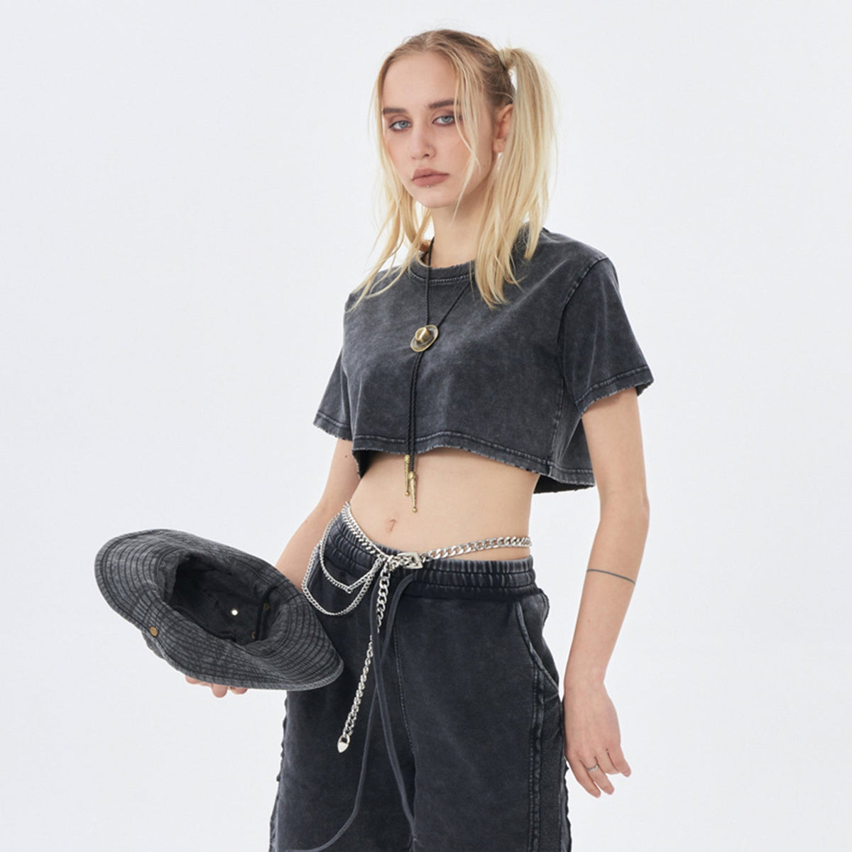 Clothing By Hot Takes Designs vintage wash black distressed cropped t-shirt worn by a blonde model with a bucket hat