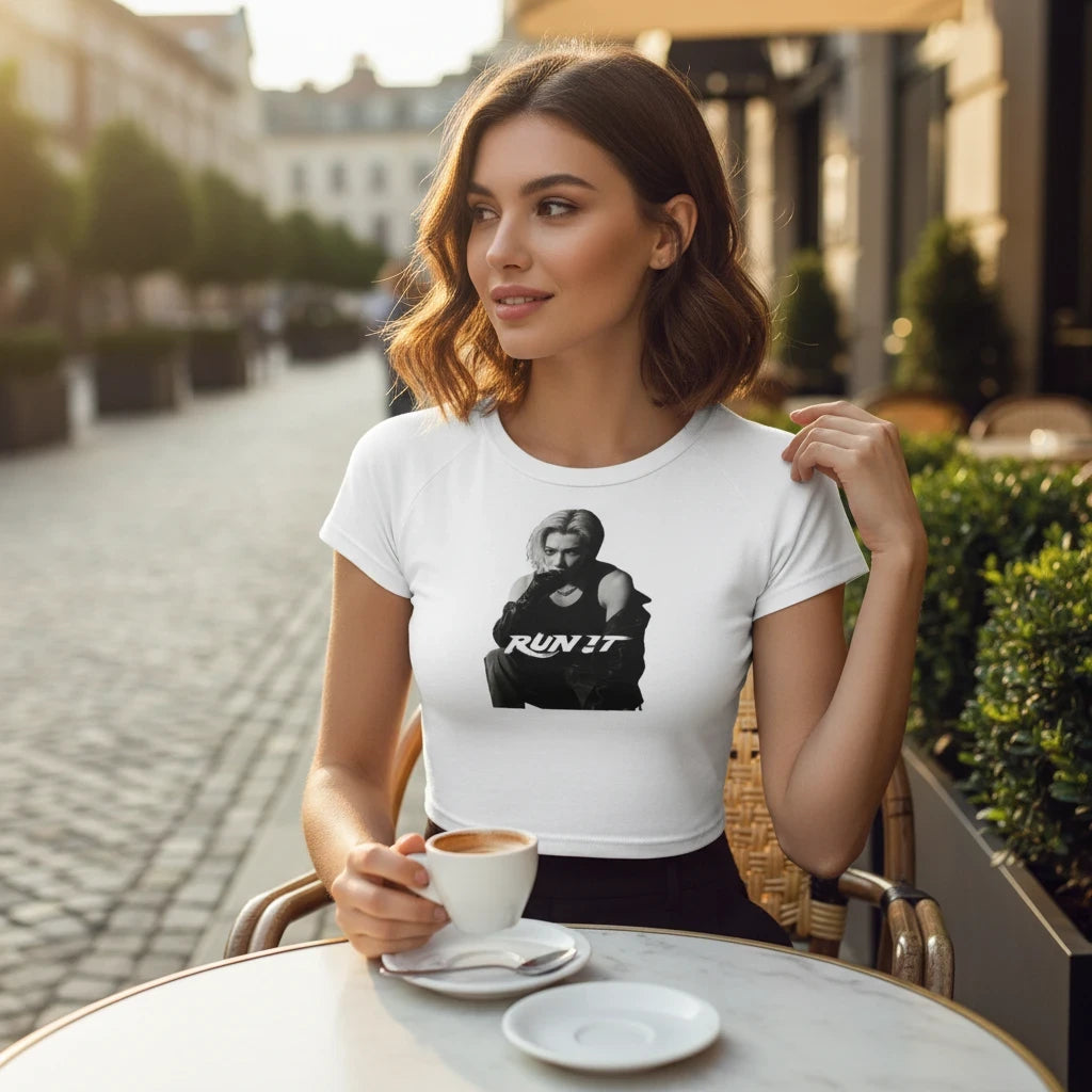 Clothing By Hot Takes Designs white fitted crop top with Felix Run It graphic, worn by a woman at an outdoor cafe.