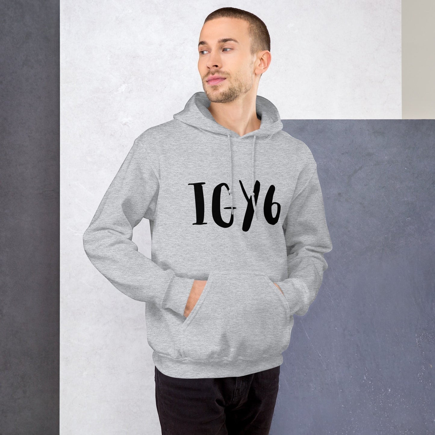 Clothing By Hot Takes Designs grey unisex hoodie with IGY6 graphic worn by a man against a minimalist studio backdrop.
