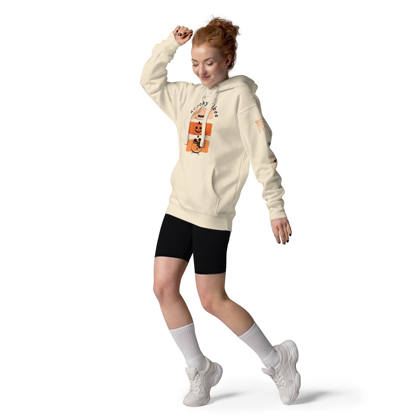 Clothing By Hot Takes Designs cream retro Halloween hoodie with pumpkin graphic, worn by a woman with red hair.