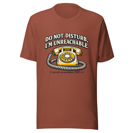 Front view mockup of a heather clay unisex t-shirt featuring a retro yellow rotary phone and graphic reading Do Not Disturb I'm Unreachable