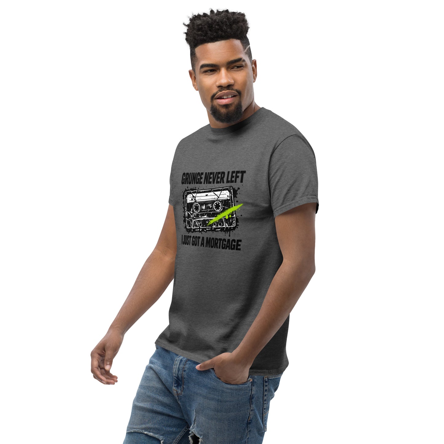 Male model wearing dark heather gray unisex t-shirt with 90s cassette graphic and text "Grunge Never Left I Just Got a Mortgage"