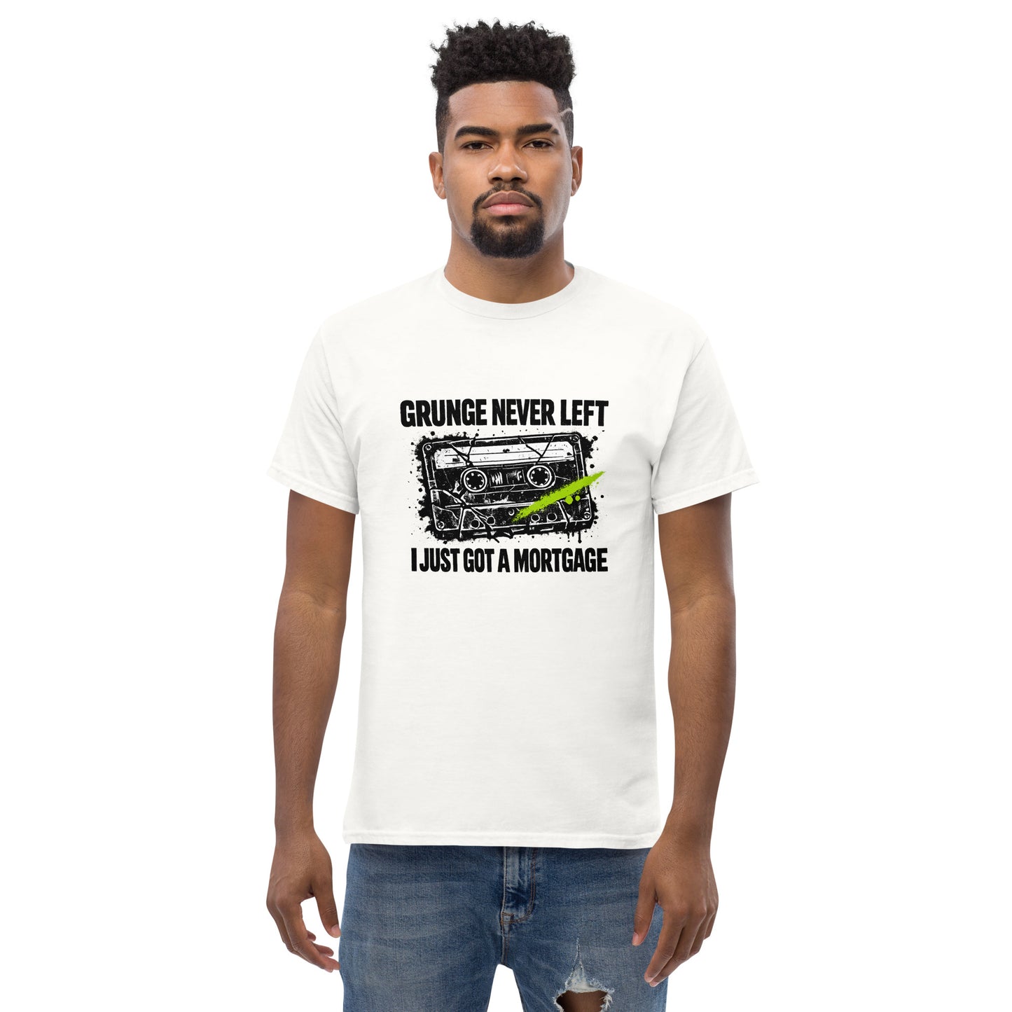 Male model wearing a white unisex t-shirt featuring a distressed 90s cassette tape graphic with the text "Grunge Never Left I Just Got a Mortgage"