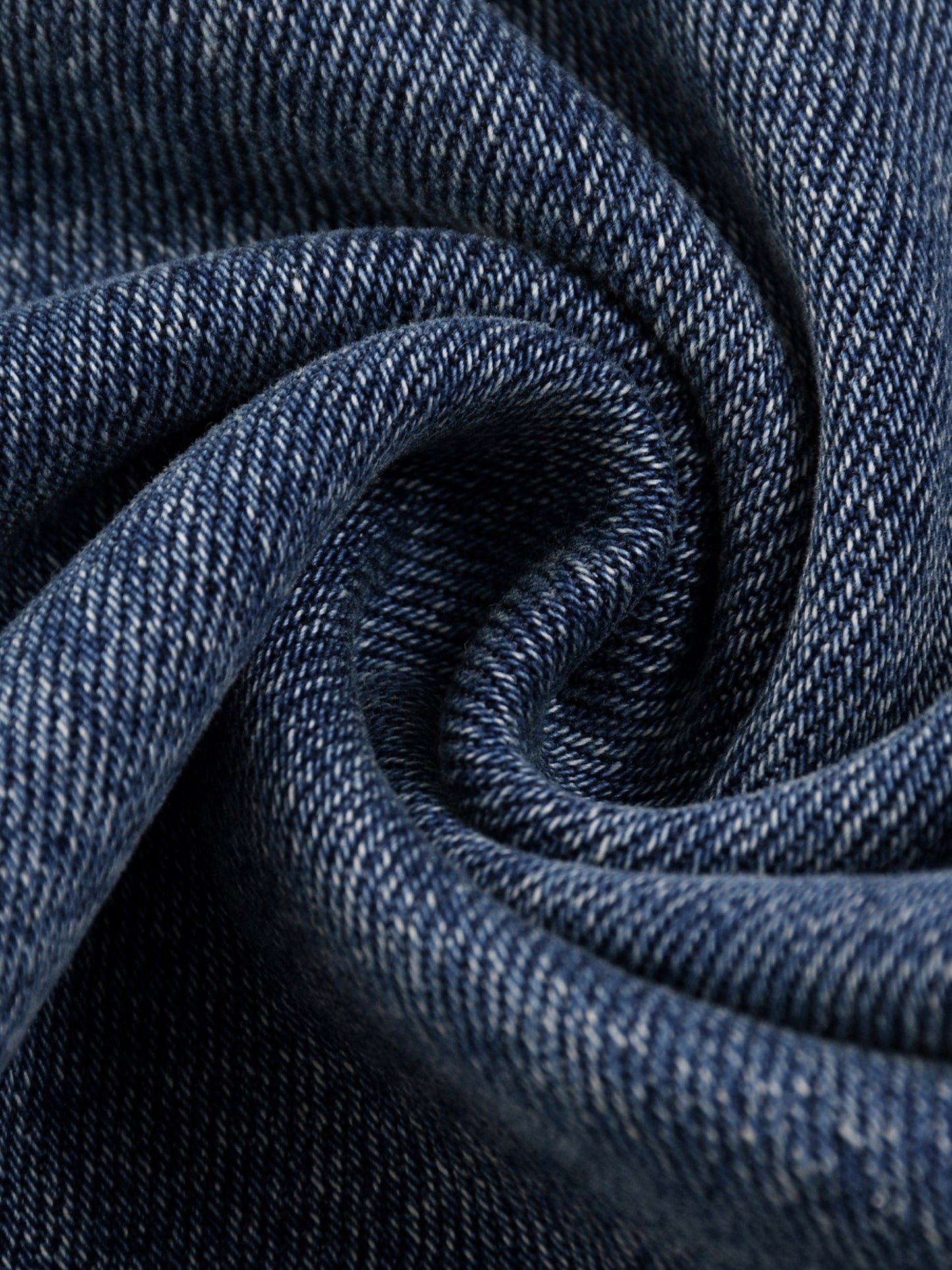 Macro textured shot of the premium 16oz blue denim fabric blend, displaying the authentic sun-fade washed finish and dense yarn fibers.