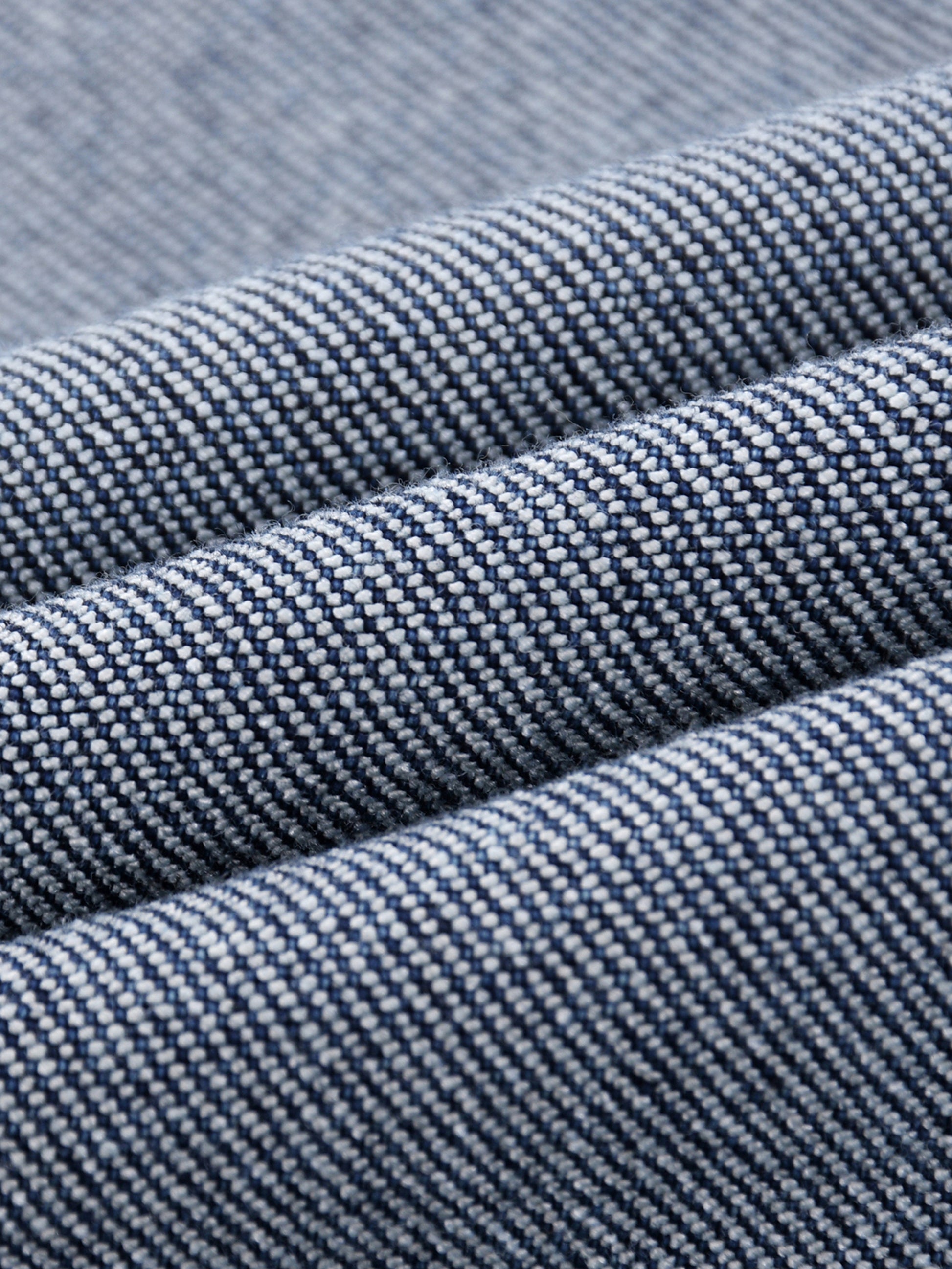 acro close-up view of the diagonal twill weave pattern and premium cotton-blend fibers of the BT21 King TATA denim jeans.