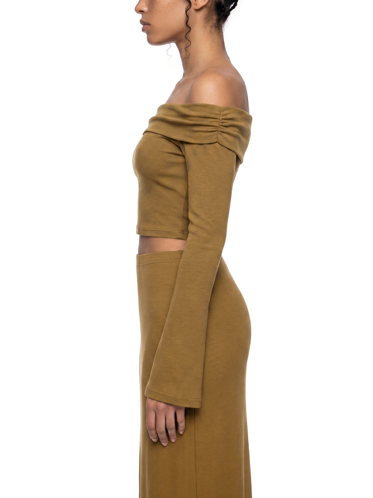 Side profile view of the brown version of the BTS Arirang off-the-shoulder crop top, highlighting the form-fitting bodice and long flared bell sleeve.