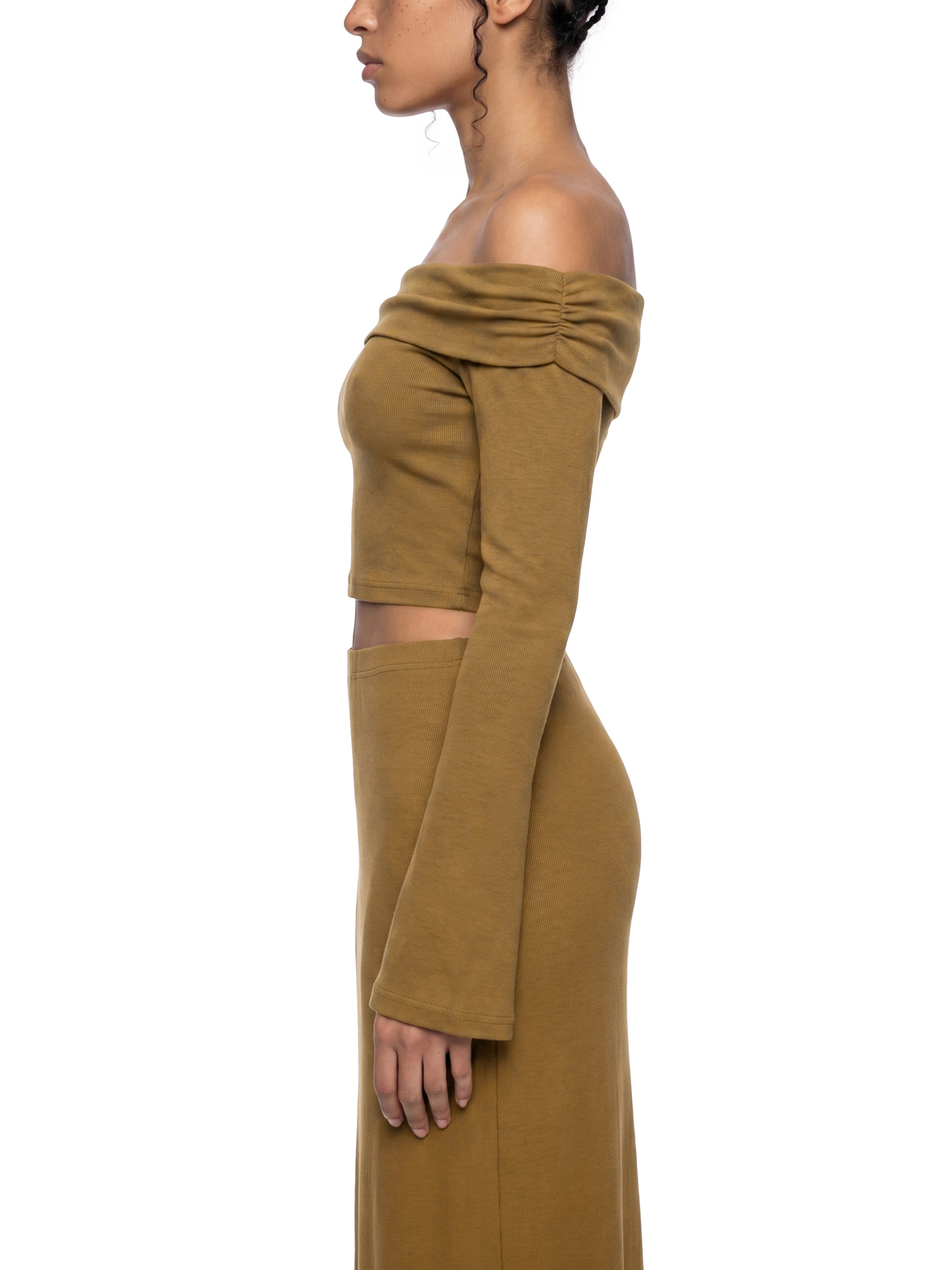 Side profile view of the brown version of the BTS Arirang off-the-shoulder crop top, highlighting the form-fitting bodice and long flared bell sleeve.