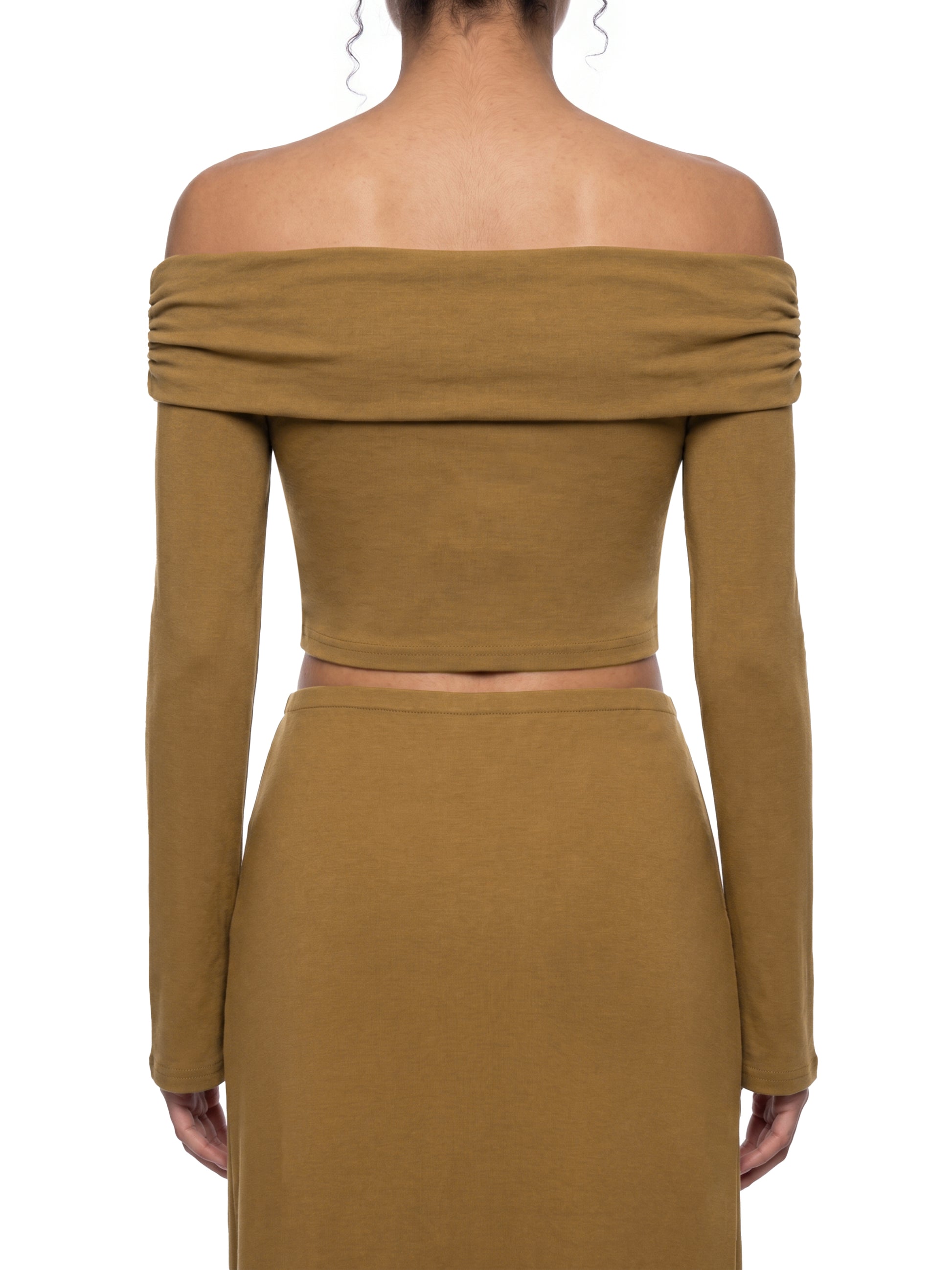 Rear view of a model wearing the brown version of the BTS Arirang off-the-shoulder crop top, highlighting the form-fitting back panel and premium long sleeve tailoring.