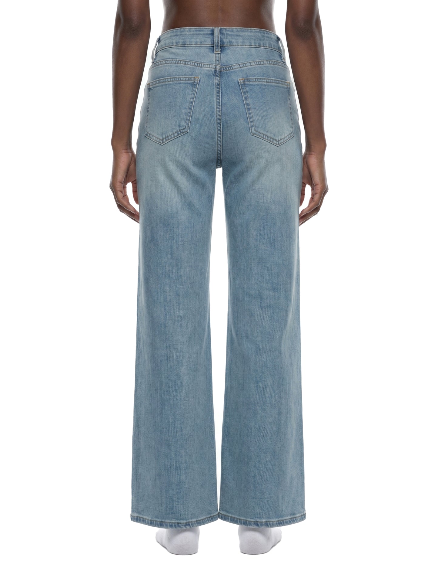 Rear view of a model wearing women's light blue flared jeans, showcasing the mid-waist fit, classic back pocket placement, and straight wide-leg silhouette.