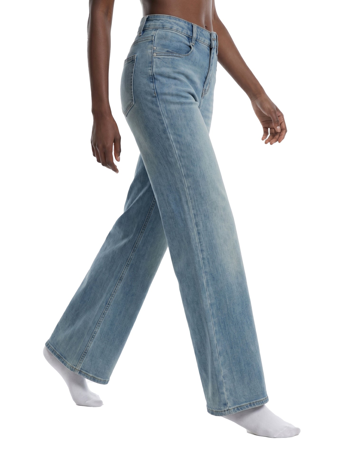 Side profile view of a model wearing women's loose fit light blue flared jeans, showcasing the mid-waist rise, hip fit, and wide flare silhouette