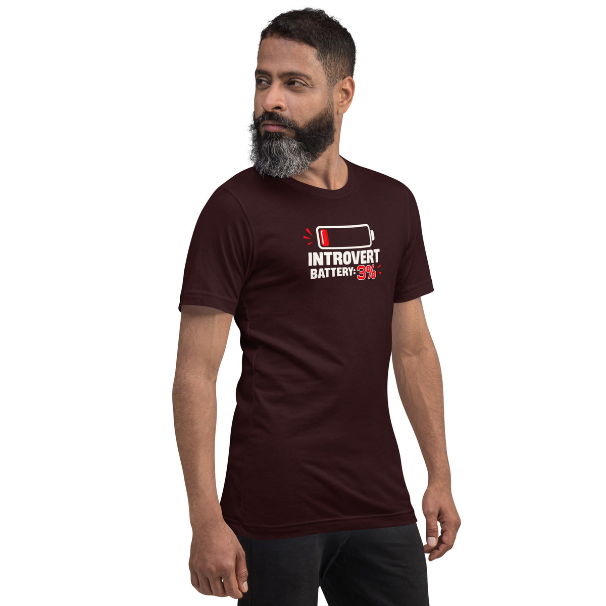 Front three-quarter view of a bearded male model wearing an oxblood black unisex t-shirt featuring a low battery icon and bold graphic reading Introvert Battery: 3%