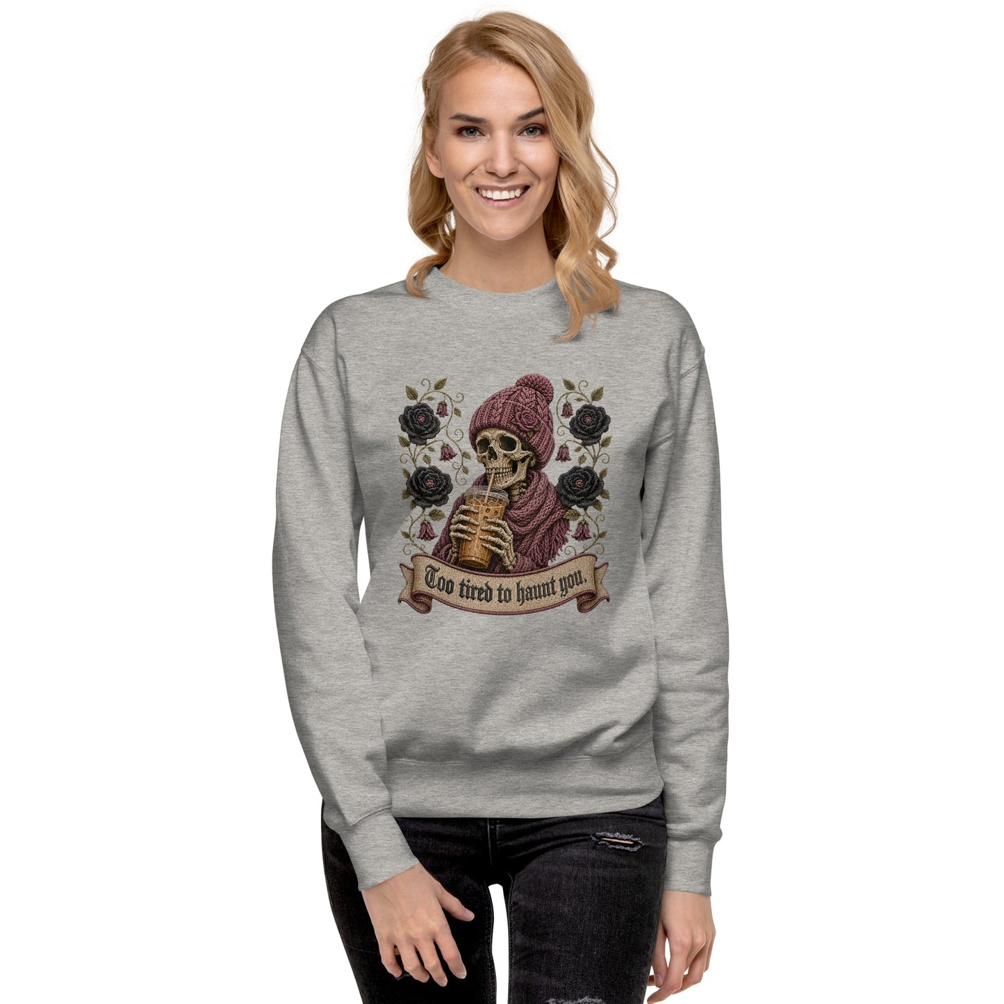 Carbon grey unisex crewneck sweatshirt mockup featuring a gothic skeleton wearing a beanie drinking iced coffee with dark roses and banner reading "Too tired to haunt you"