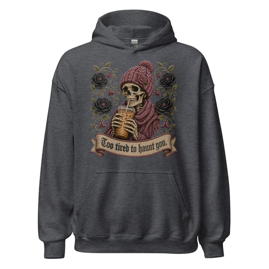 Dark heather gray unisex pullover hoodie mockup featuring a gothic skeleton wearing a knit beanie drinking iced coffee with dark roses and banner reading Too Tired to Haunt You