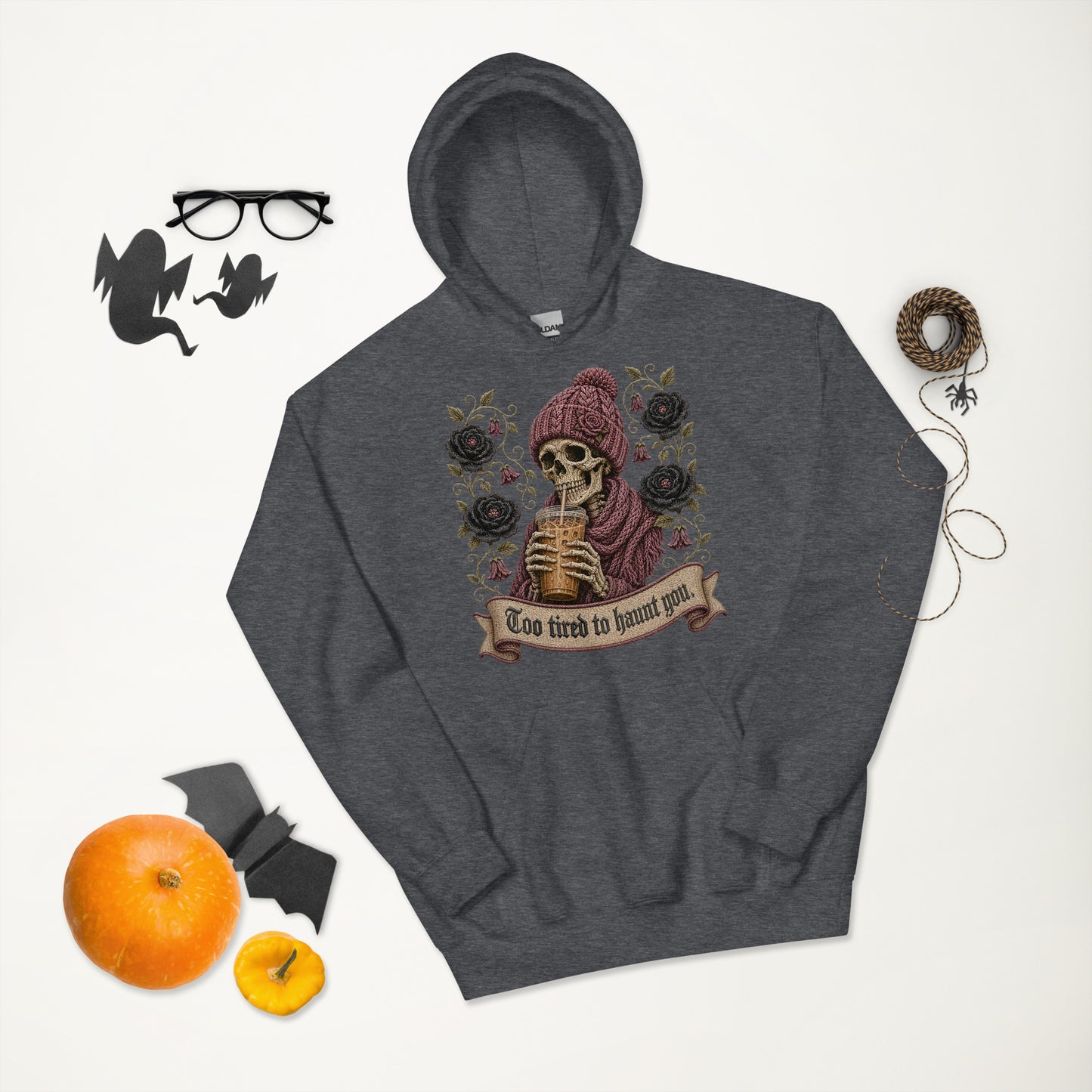 Dark heather gray unisex hoodie flat lay mockup featuring a gothic iced coffee skeleton with Halloween decor, pumpkins, glasses, and bats