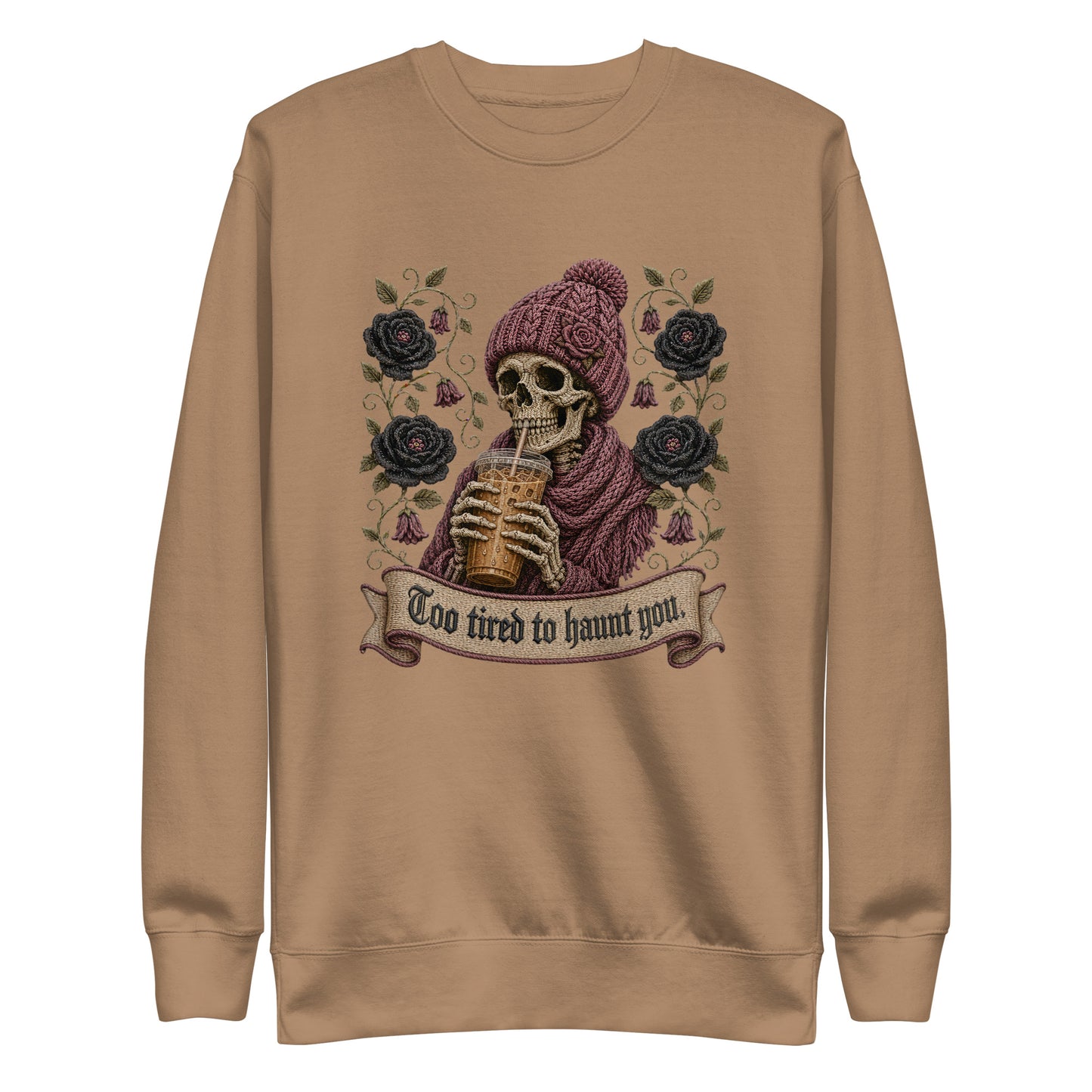 Latte beige unisex crewneck sweatshirt mockup featuring a gothic skeleton in a beanie drinking iced coffee with dark roses and banner reading "Too tired to haunt you"