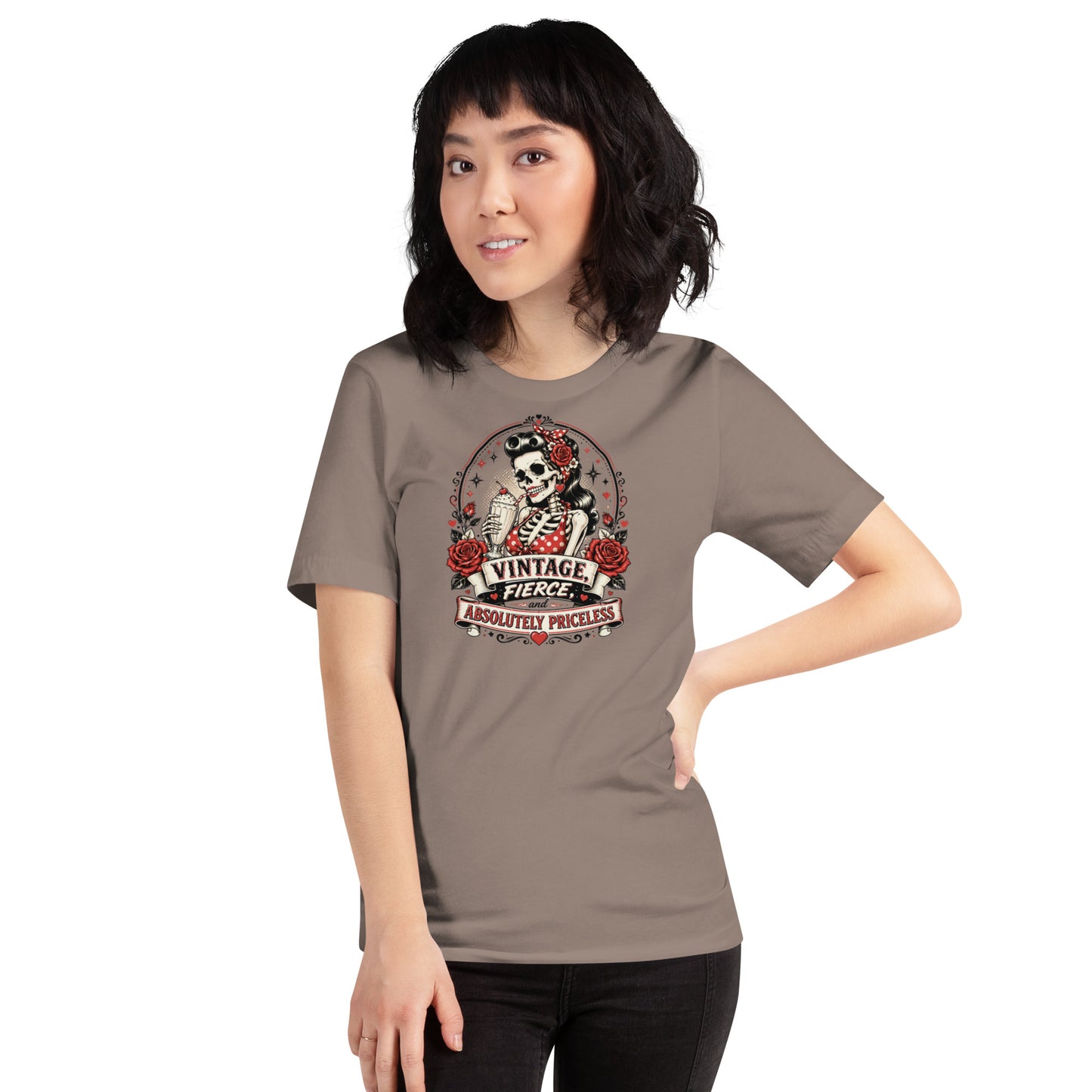 Front view of a female model wearing a pebble beige unisex graphic t-shirt featuring a rockabilly skeleton pinup girl with red roses and Vintage Fierce and Absolutely Priceless banner