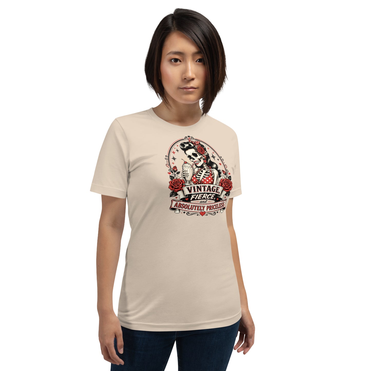 Front view of a female model wearing a soft cream unisex graphic t-shirt featuring a rockabilly skeleton pinup girl holding a sundae with red roses and banner reading Vintage Fierce and Absolutely Priceless